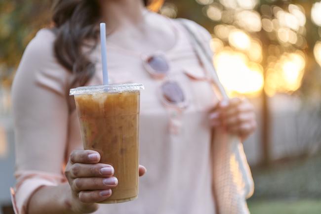 woman holding cup of iced coffee
